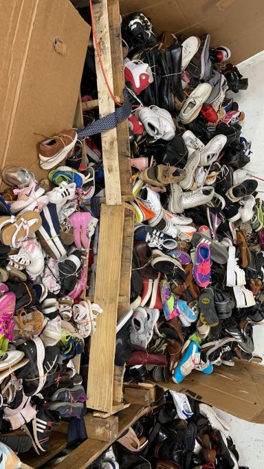 A pile of shoes in a cardboard box.